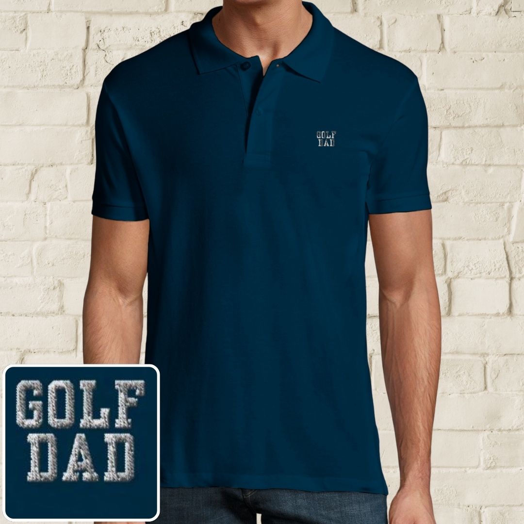 Golf Dad Polo in Denim on a light wooden floor lying next to headphones and golf shoes.