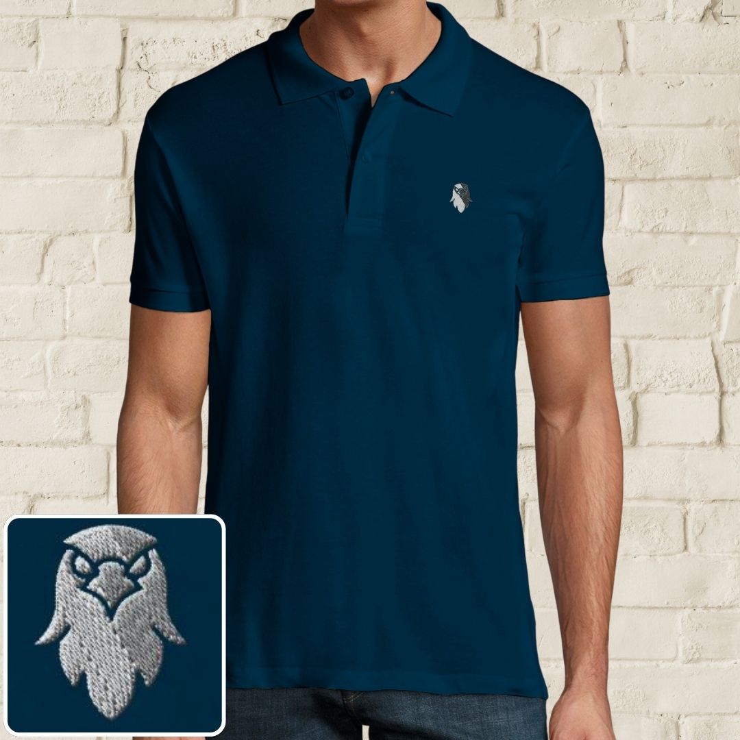 Eagle Polo in Denim on a light wooden floor lying next to headphones and golf shoes.