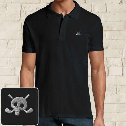 Skull Polo in Black on a light wooden floor lying next to headphones and golf shoes.