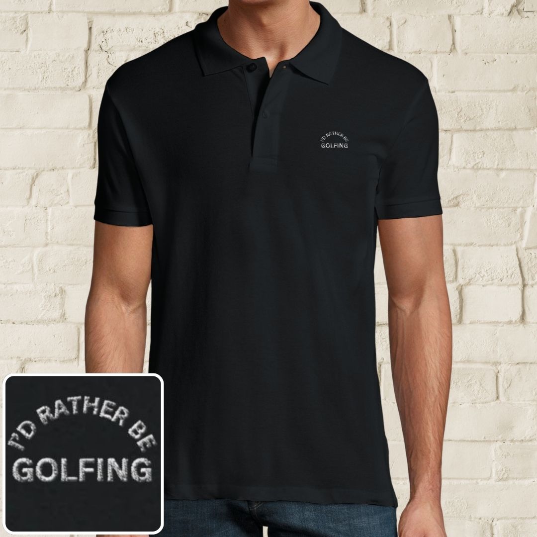 Rather Golfing Polo in Black on a light wooden floor lying next to headphones and golf shoes.