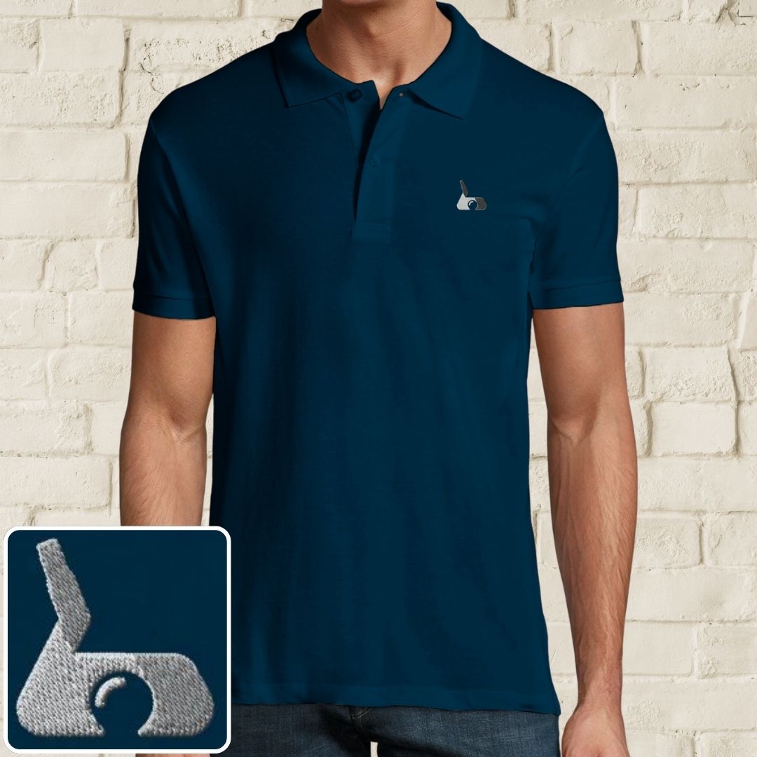 Putter Polo in Denim on a light wooden floor lying next to headphones and golf shoes.