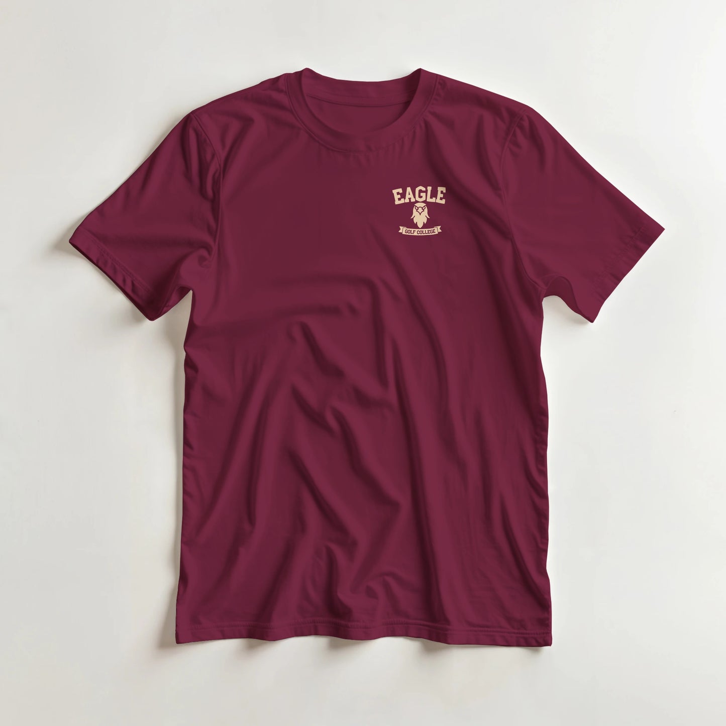 Eagle College (Pocket) T-Shirt in Maroon lying on a plain floor. T-shirt is a unisex cut and 100 per cent cotton.