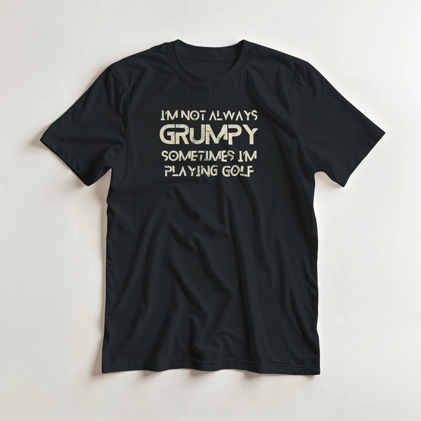 Grumpy Golf T-Shirt in Black lying on a plain floor. T-shirt is a unisex cut and 100 per cent cotton.