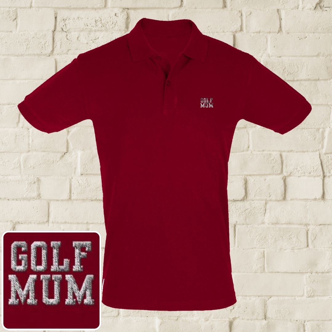 Golf Mum Polo in Maroon on a light wooden floor lying next to headphones and golf shoes.