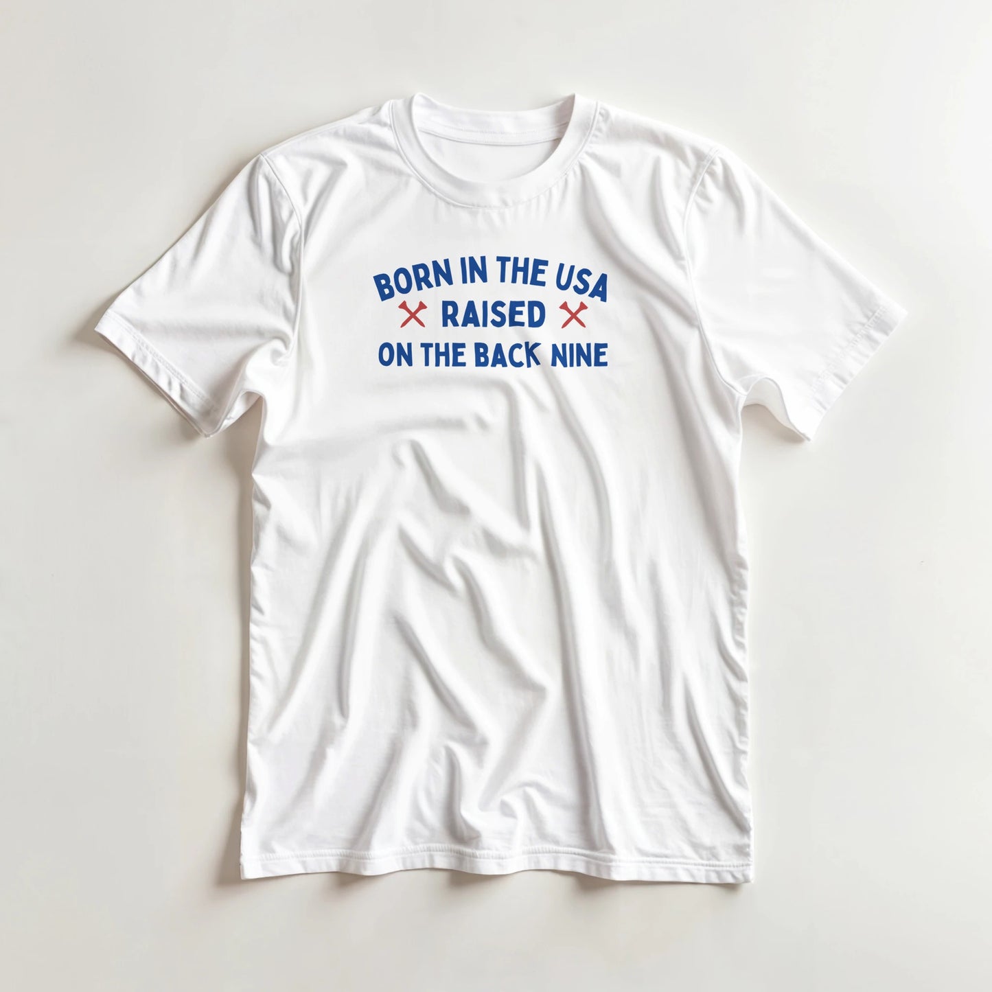 Born In The USA T-Shirt in lying on a plain floor. T-shirt is a unisex cut and 100 per cent cotton.