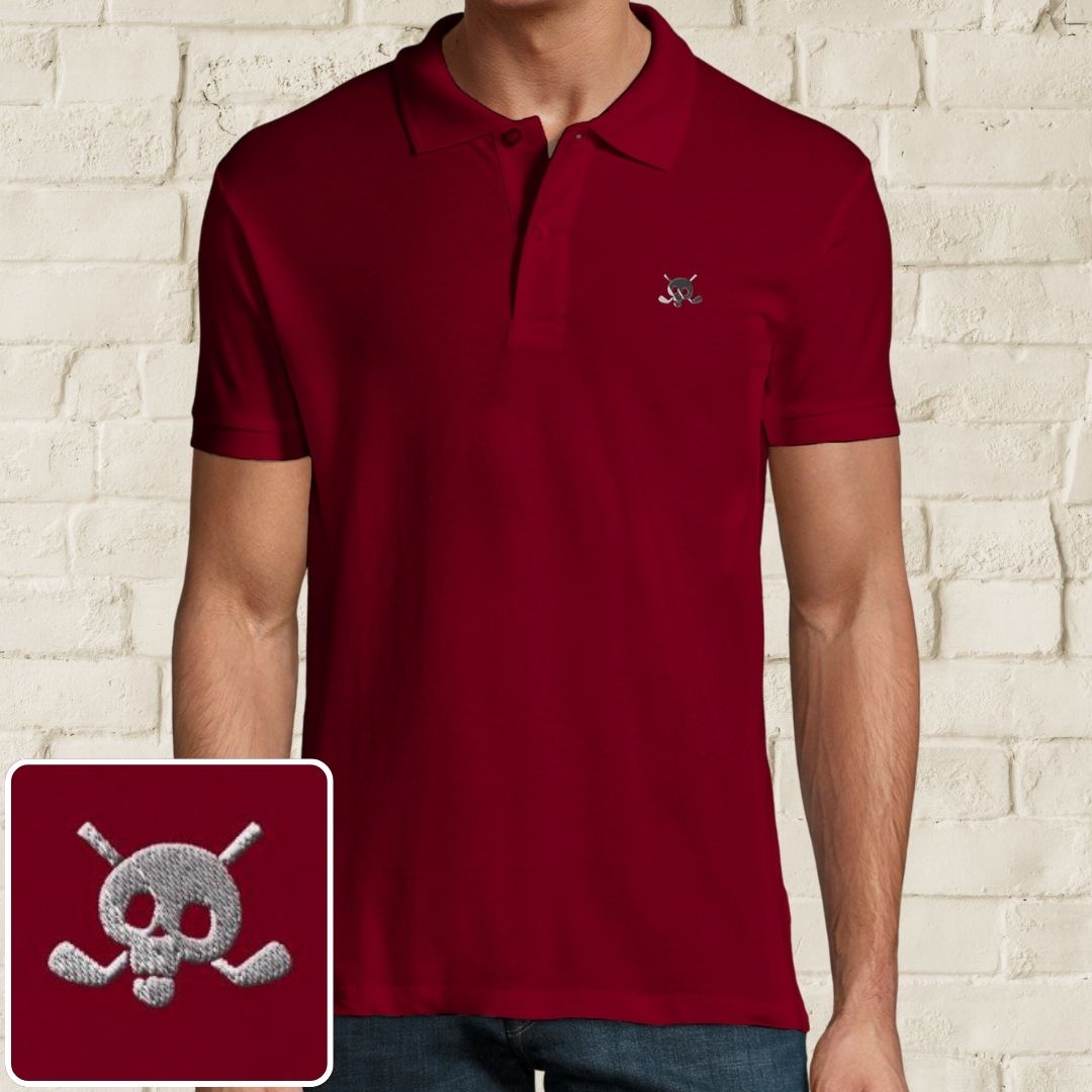Skull Polo in Maroon on a light wooden floor lying next to headphones and golf shoes.