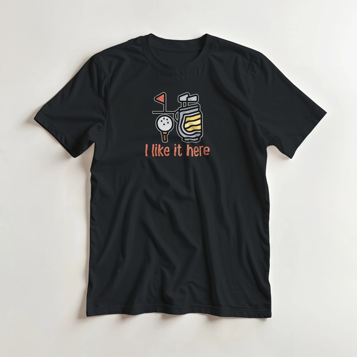 I Like It Here T-Shirt in Black lying on a plain floor. T-shirt is a unisex cut and 100 per cent cotton.
