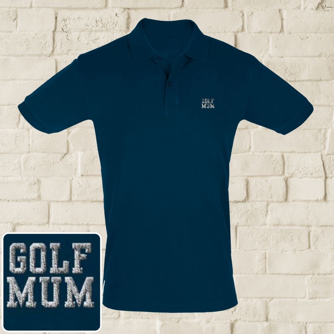 Golf Mum Polo in Denim on a light wooden floor lying next to headphones and golf shoes.