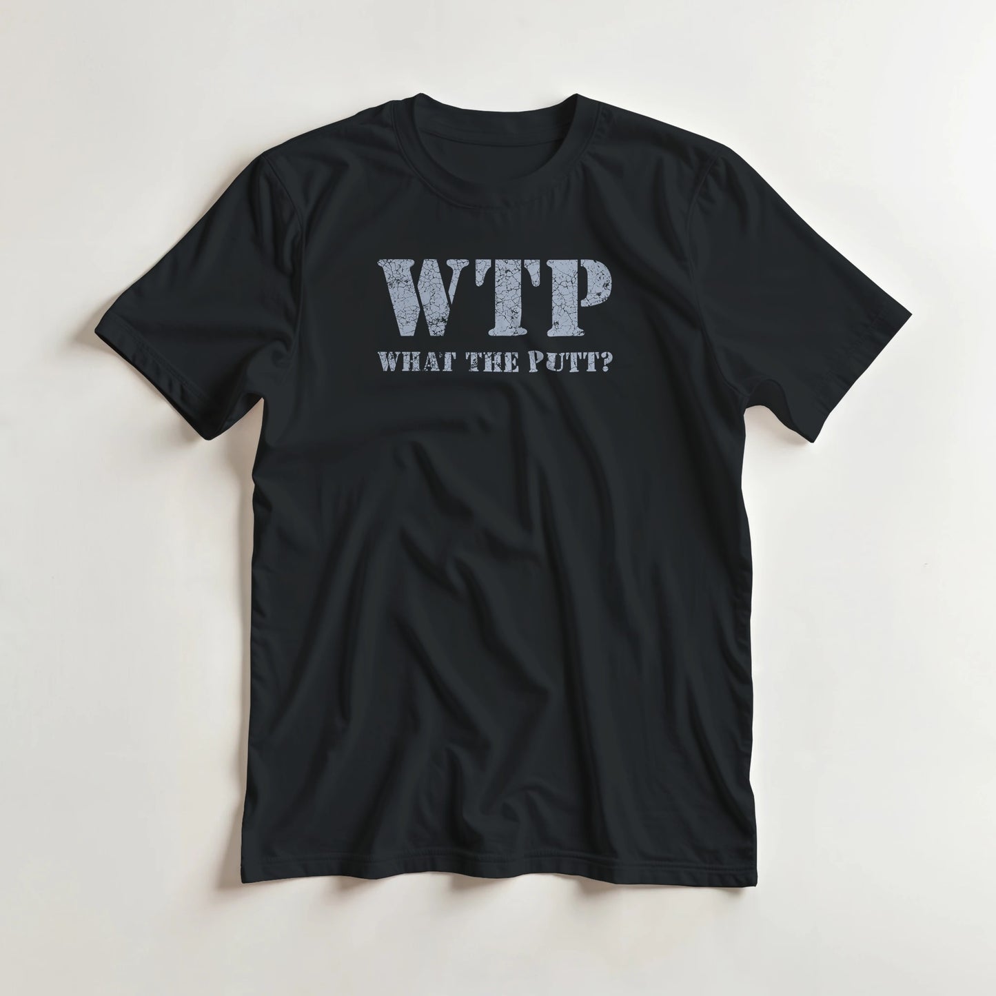 What The Putt T-Shirt in Black lying on a plain floor. T-shirt is a unisex cut and 100 per cent cotton.