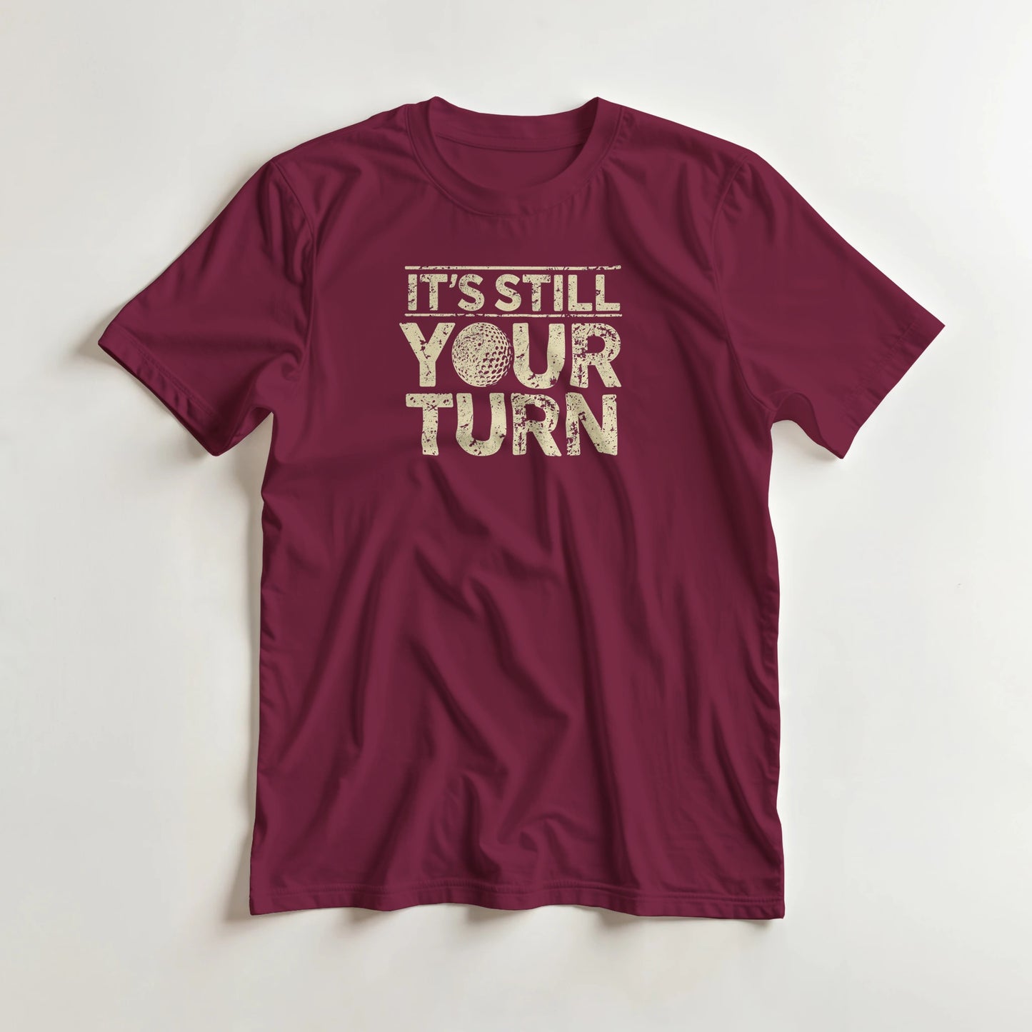 Your Turn T-Shirt in Maroon lying on a plain floor. T-shirt is a unisex cut and 100 per cent cotton.