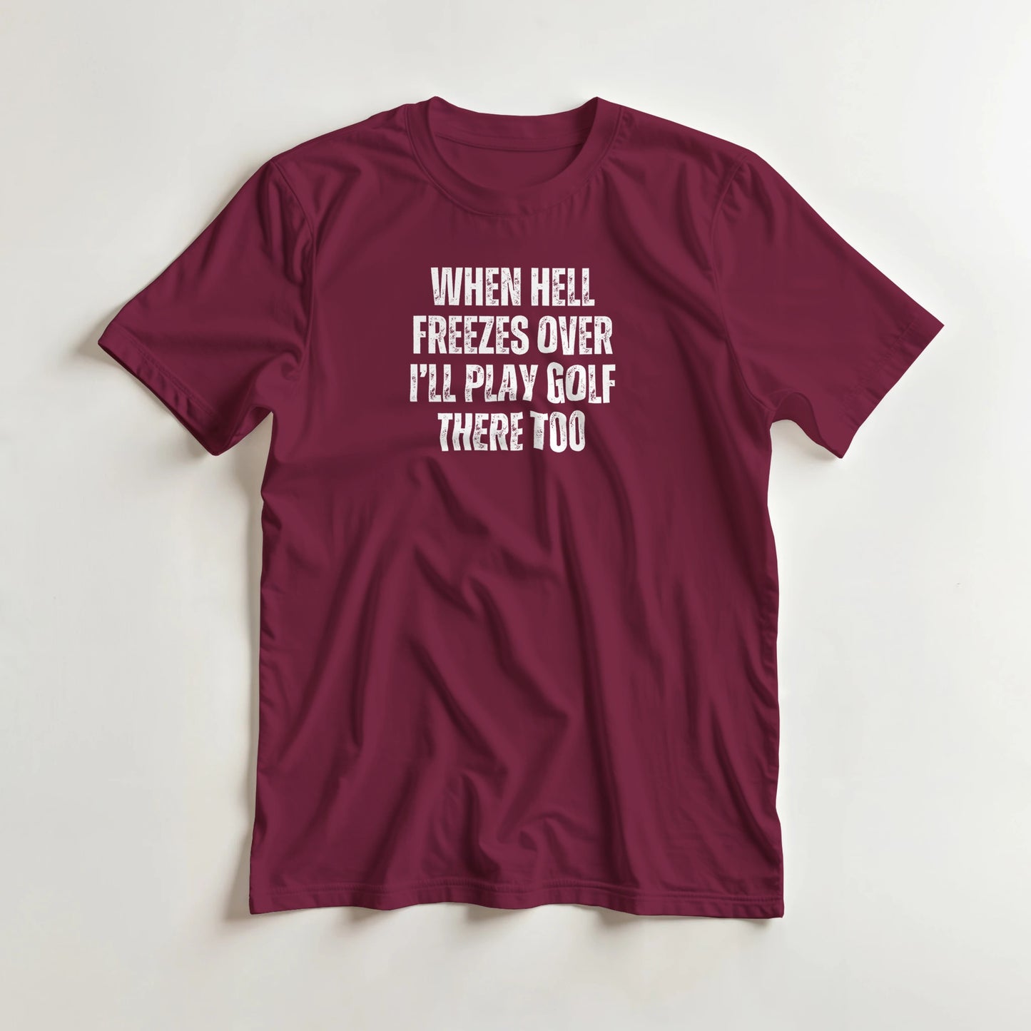 Hell Freezes T-Shirt in Maroon lying on a plain floor. T-shirt is a unisex cut and 100 per cent cotton.