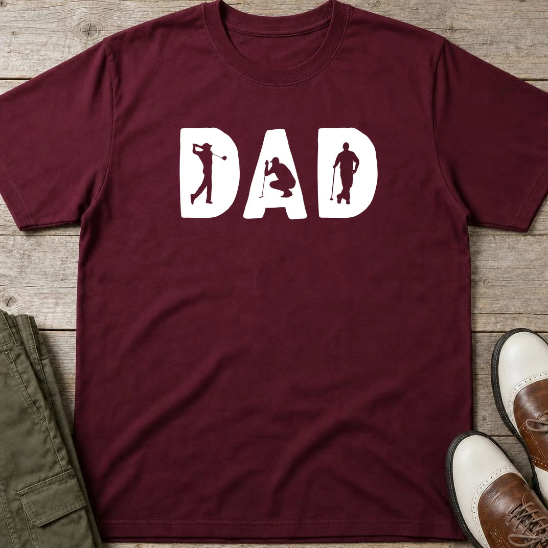 Golf Dad T-Shirt in Maroon lying on a plain floor. T-shirt is a unisex cut and 100 per cent cotton.