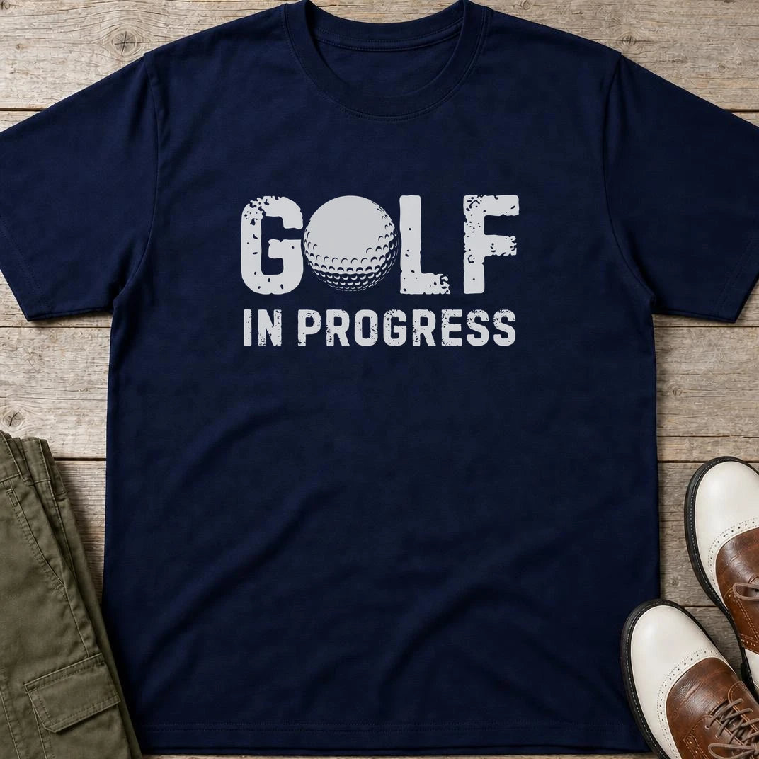 Golf In Progress T-Shirt in Navy lying on a plain floor. T-shirt is a unisex cut and 100 per cent cotton.