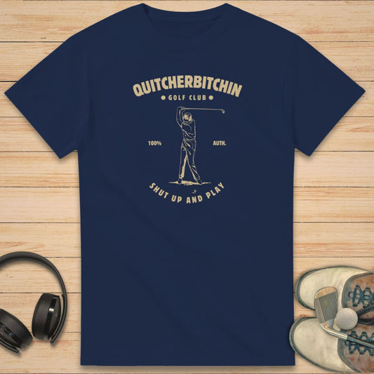 Quitcherbitchin T-Shirt in Navy on a light wooden floor lying next to headphones and golf shoes.