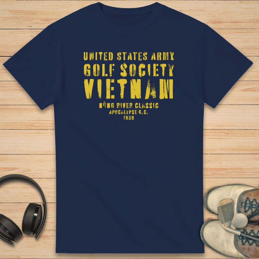 Apocalypse G.C. T-Shirt in Navy on a light wooden floor lying next to headphones and golf shoes.