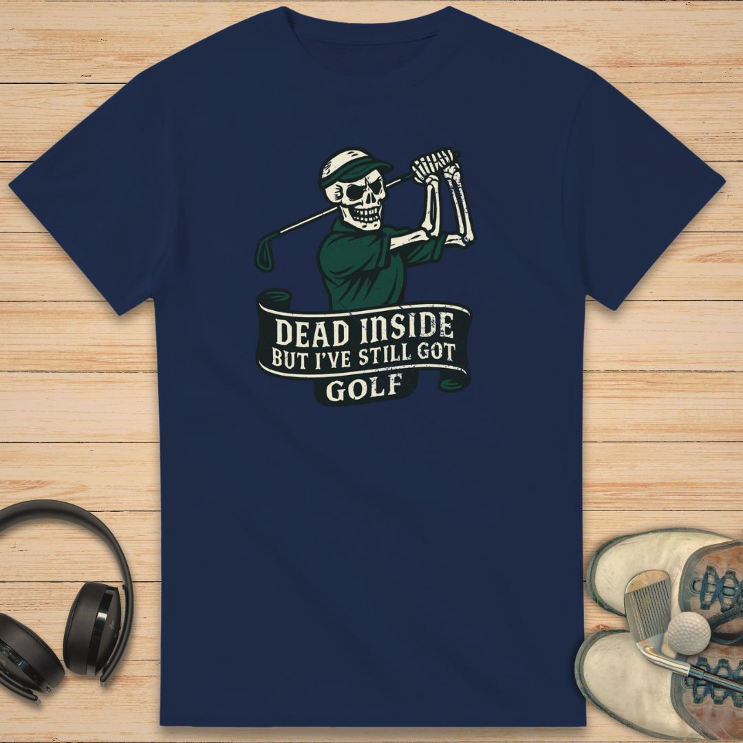 Dead Inside T-Shirt in Navy on a light wooden floor lying next to headphones and golf shoes.