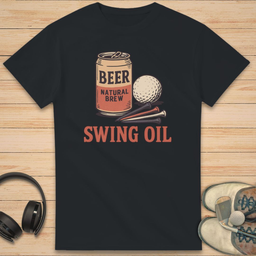 Swing Oil T-Shirt in Black on a light wooden floor lying next to headphones and golf shoes.