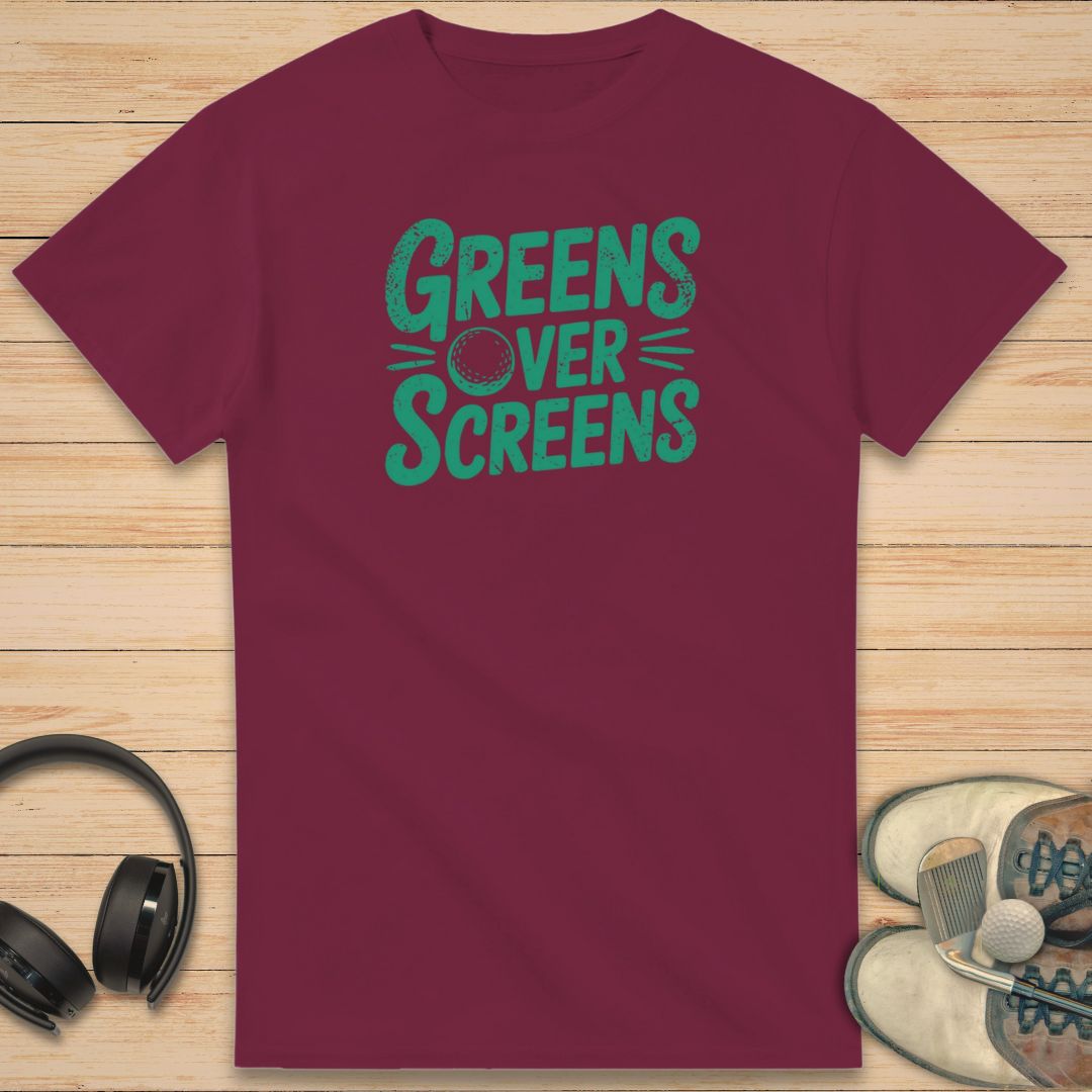 Over Screens T-Shirt in Maroon on a light wooden floor lying next to headphones and golf shoes.