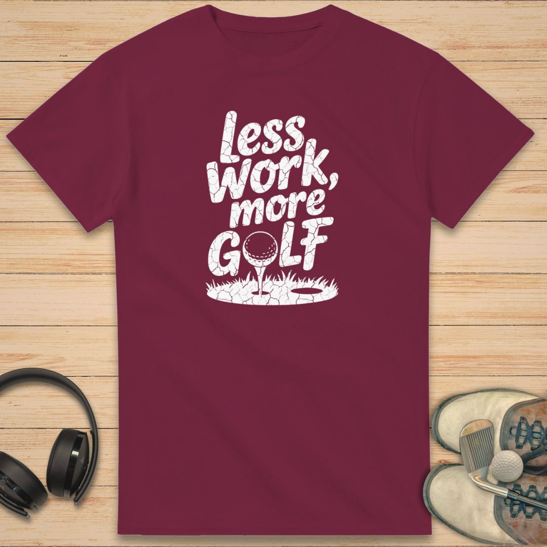 More Golf T-Shirt in Maroon on a light wooden floor lying next to headphones and golf shoes.