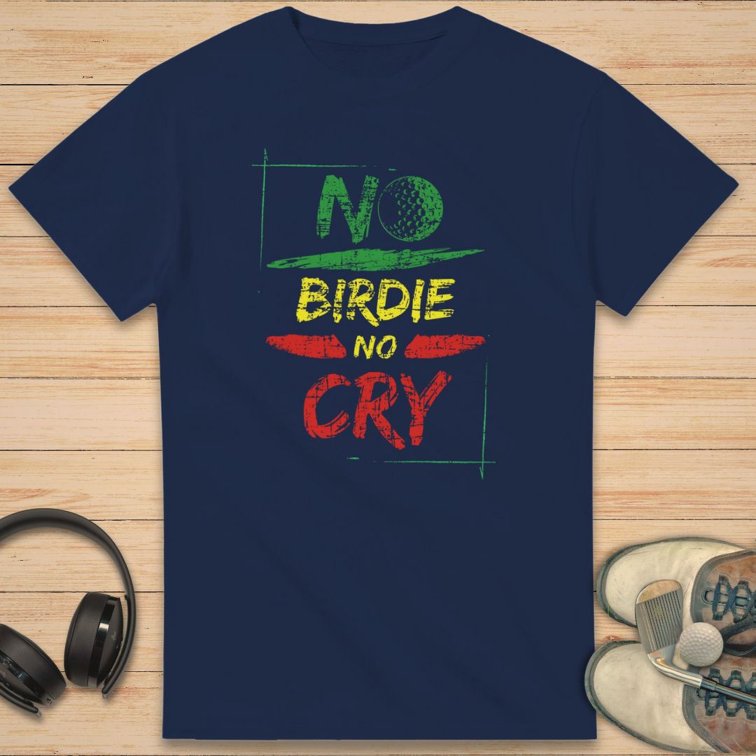 No Birdie No Cry T-Shirt in Navy on a light wooden floor lying next to headphones and golf shoes.