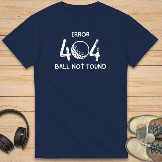 Error 404 T-Shirt in Navy on a light wooden floor lying next to headphones and golf shoes.