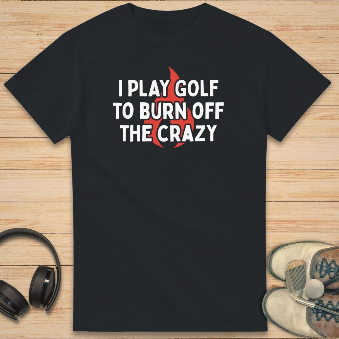 Burn Off T-Shirt in Black on a light wooden floor lying next to headphones and golf shoes.