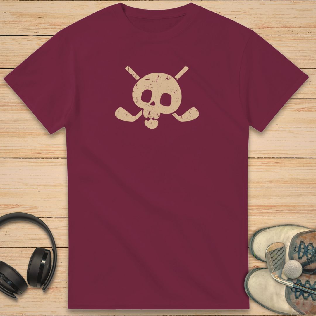Skull X-Clubs T-Shirt in Maroon on a light wooden floor lying next to headphones and golf shoes.