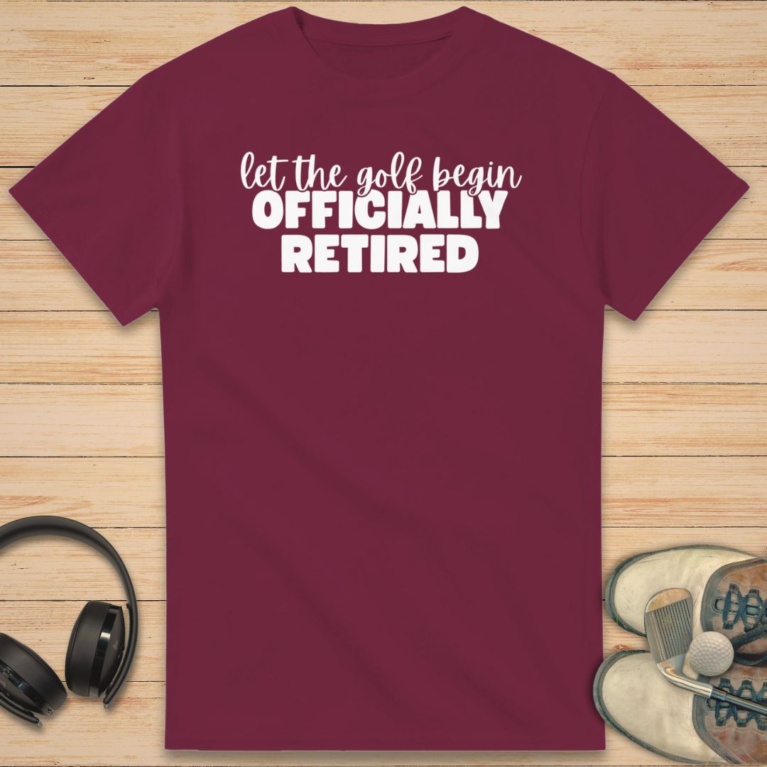 Golf Begin T-Shirt in Maroon on a light wooden floor lying next to headphones and golf shoes.