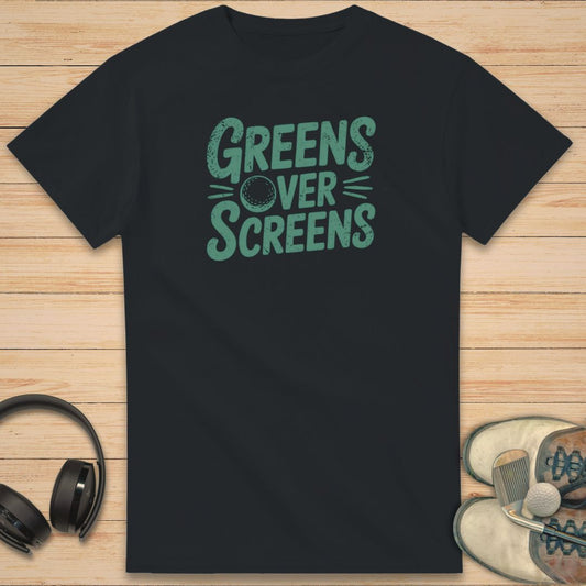 Over Screens T-Shirt in Black on a light wooden floor lying next to headphones and golf shoes.