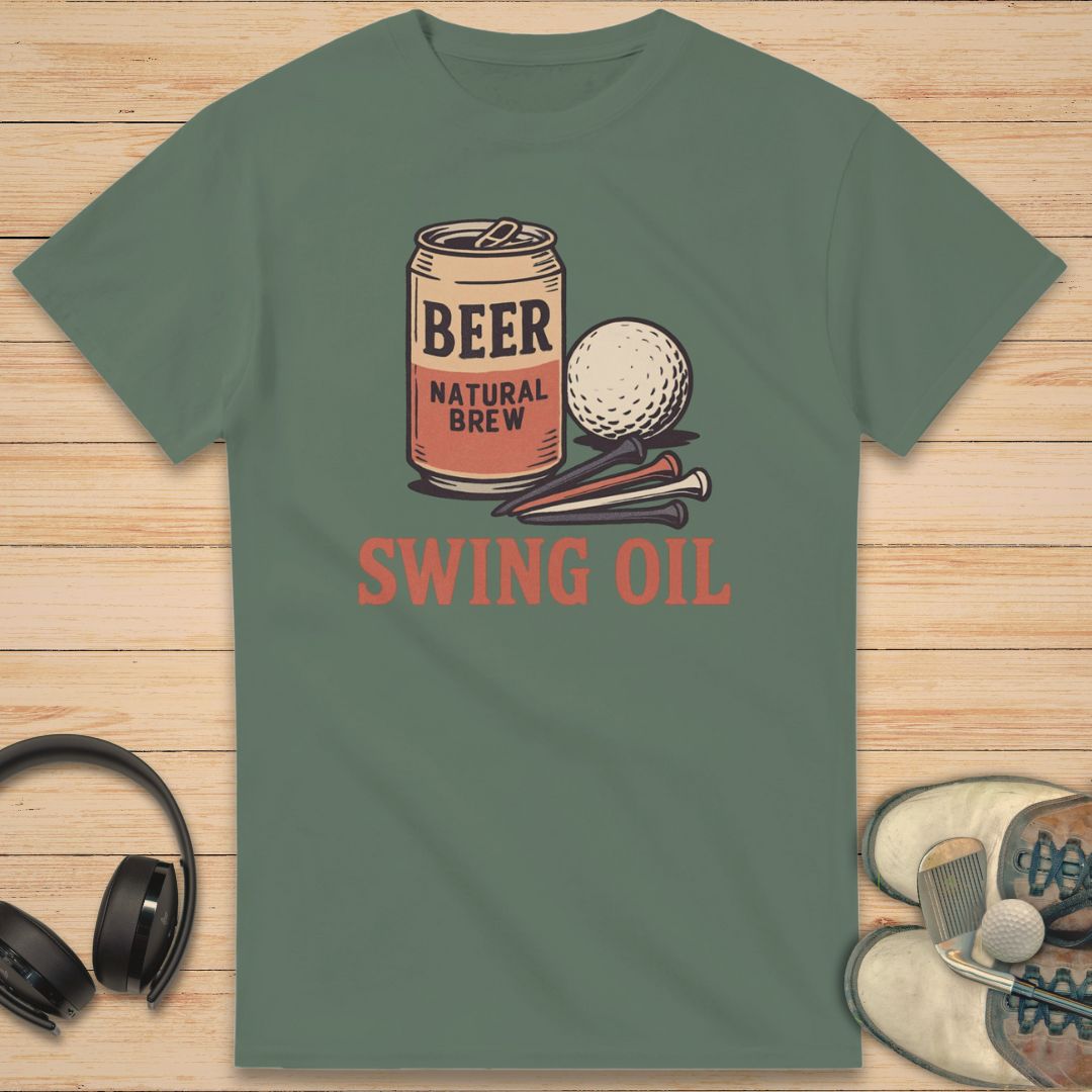 Swing Oil T-Shirt in Military Green on a light wooden floor lying next to headphones and golf shoes.
