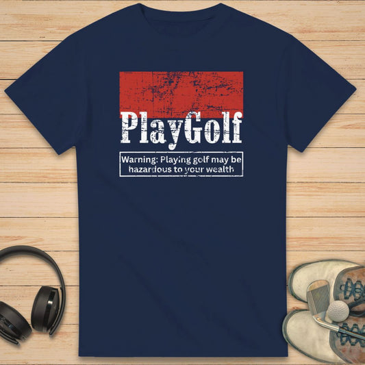Play Golf T-Shirt in Navy on a light wooden floor lying next to headphones and golf shoes.