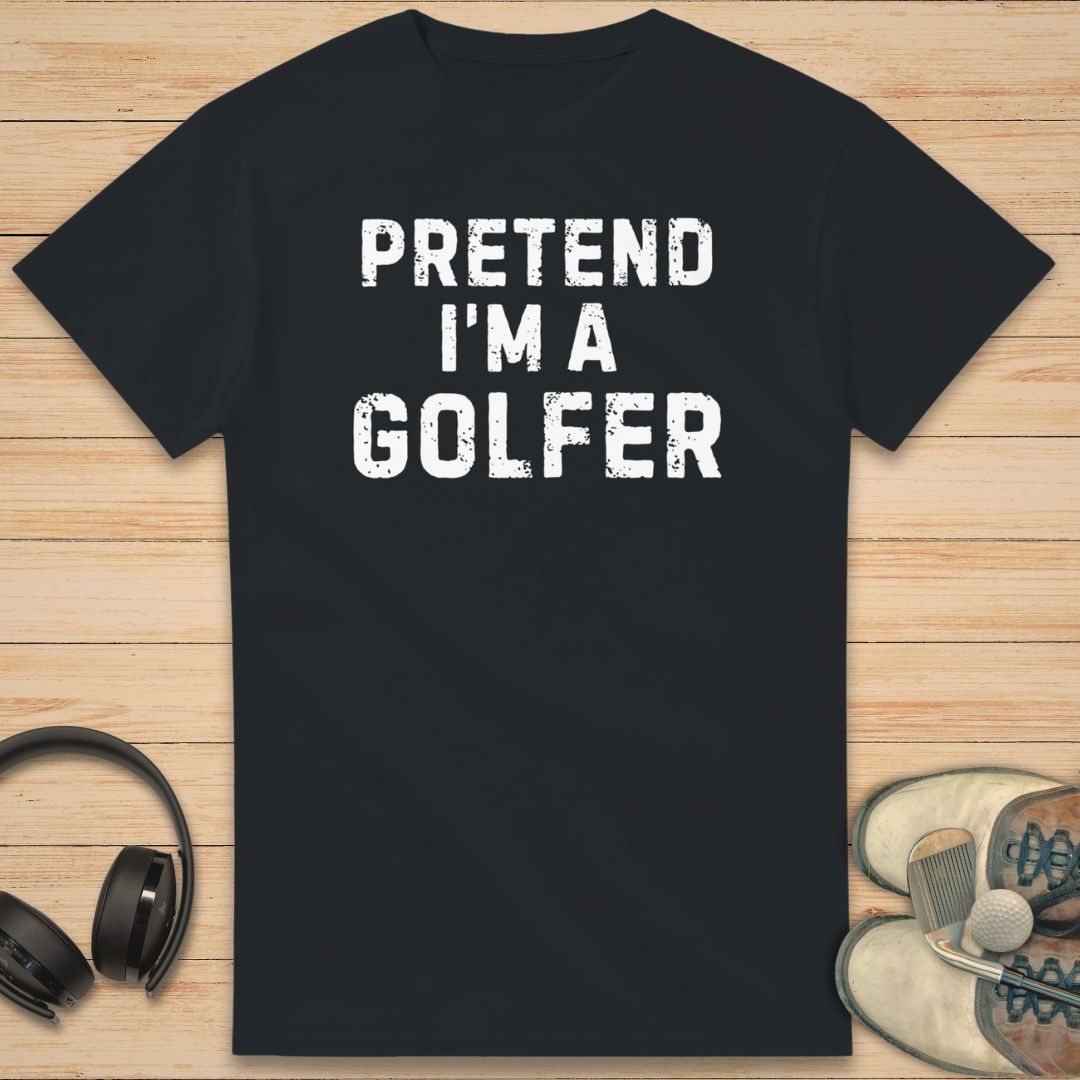 Black t-shirt with 'Pretend I'm a Golfer' text on a wooden surface with headphones and shoes.