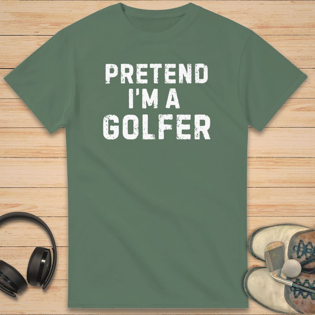 Green t-shirt with 'Pretend I'm a Golfer' text on a wooden surface with headphones and shoes.
