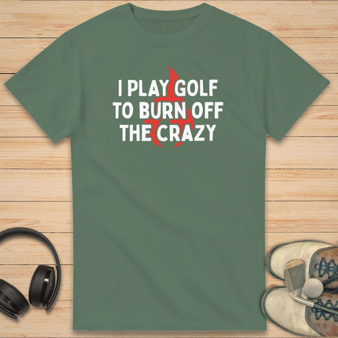 Burn Off T-Shirt in Military Green on a light wooden floor lying next to headphones and golf shoes.