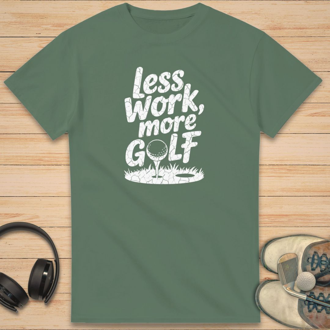 More Golf T-Shirt in Military Green on a light wooden floor lying next to headphones and golf shoes.