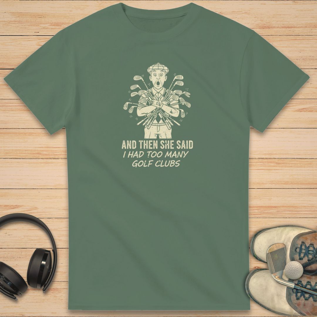 She Said T-Shirt in Military Green on a light wooden floor lying next to headphones and golf shoes.