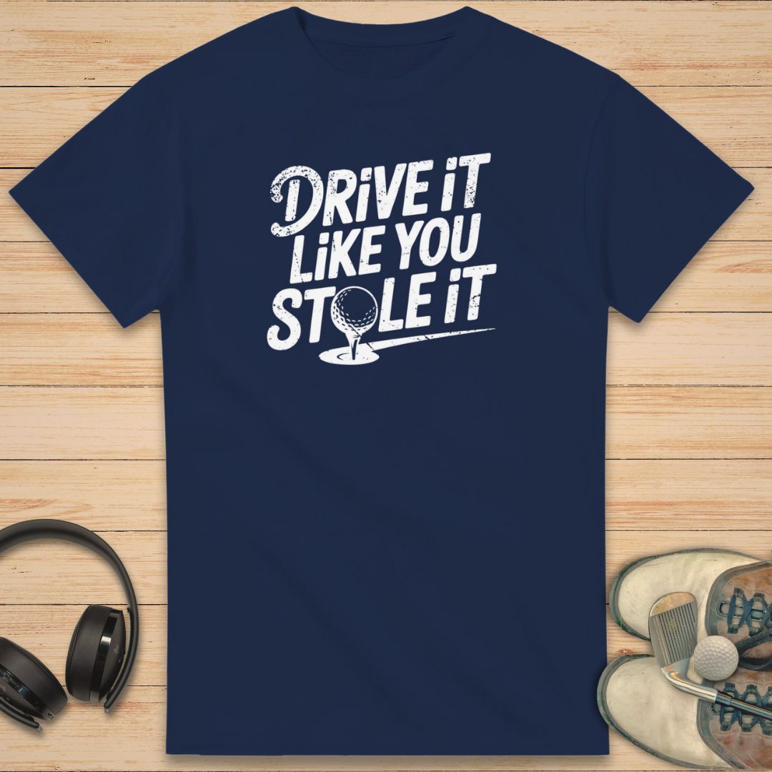 Stole It T-Shirt in Navy on a light wooden floor lying next to headphones and golf shoes.