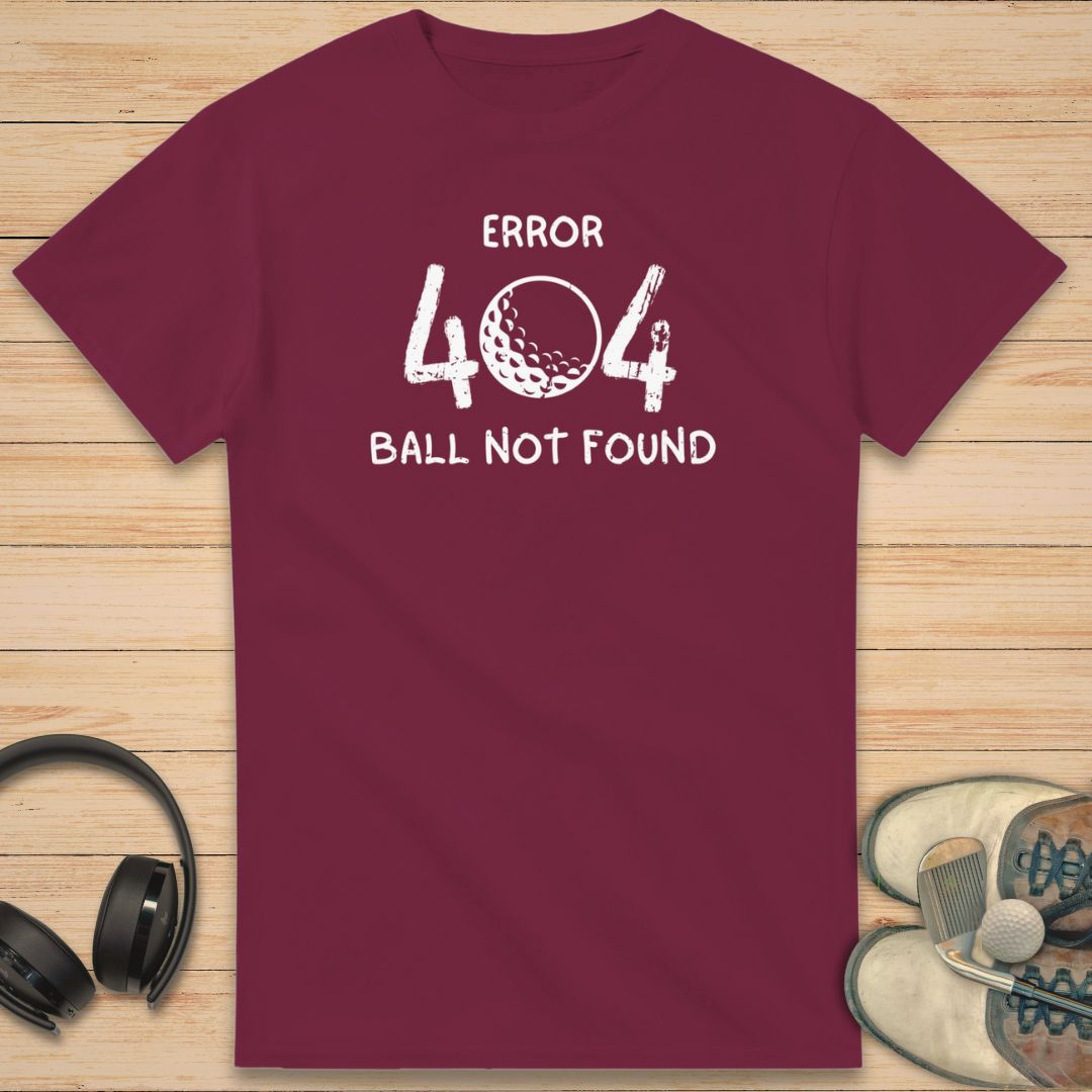 Error 404 T-Shirt in Maroon on a light wooden floor lying next to headphones and golf shoes.