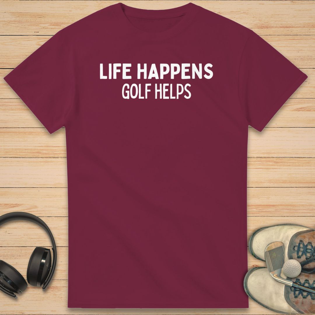 Golf Helps T-Shirt in Maroon on a light wooden floor lying next to headphones and golf shoes.