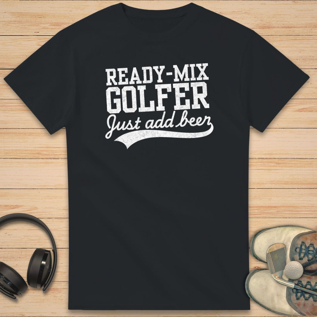 Ready-Mix T-Shirt in Black on a light wooden floor lying next to headphones and golf shoes.