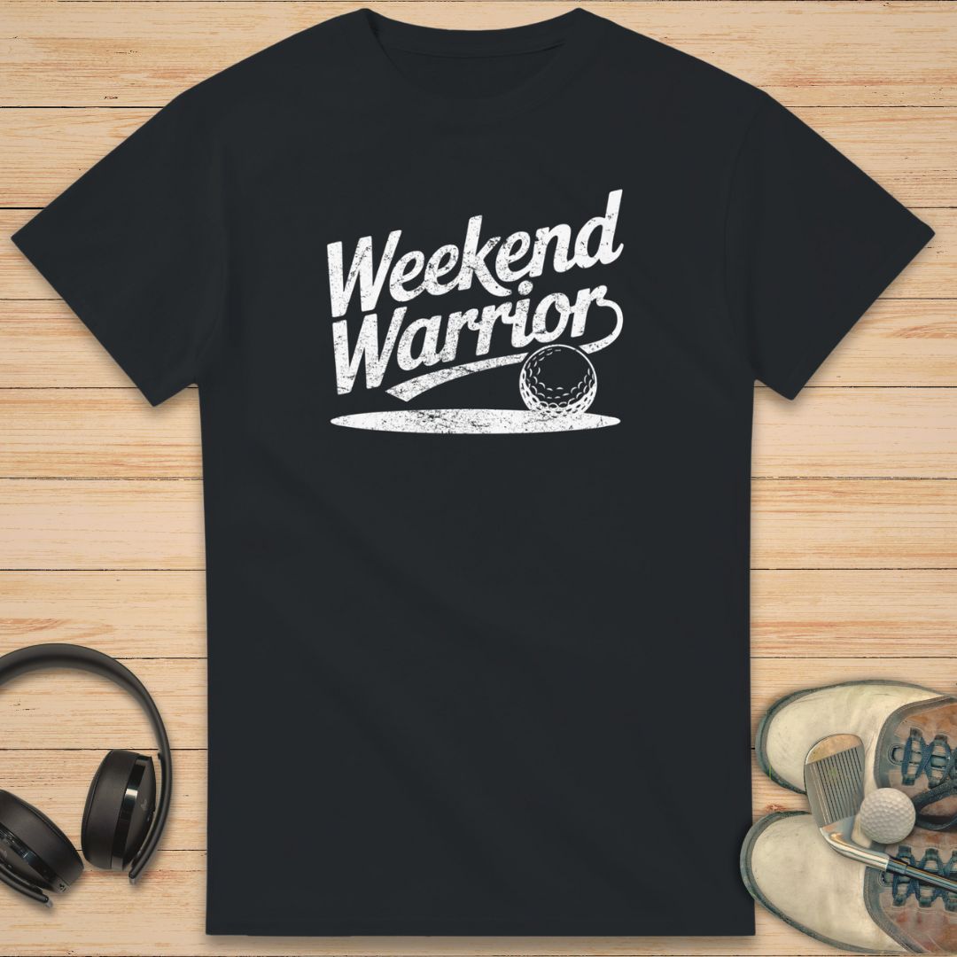 Warrior T-Shirt in Black on a light wooden floor lying next to headphones and golf shoes.