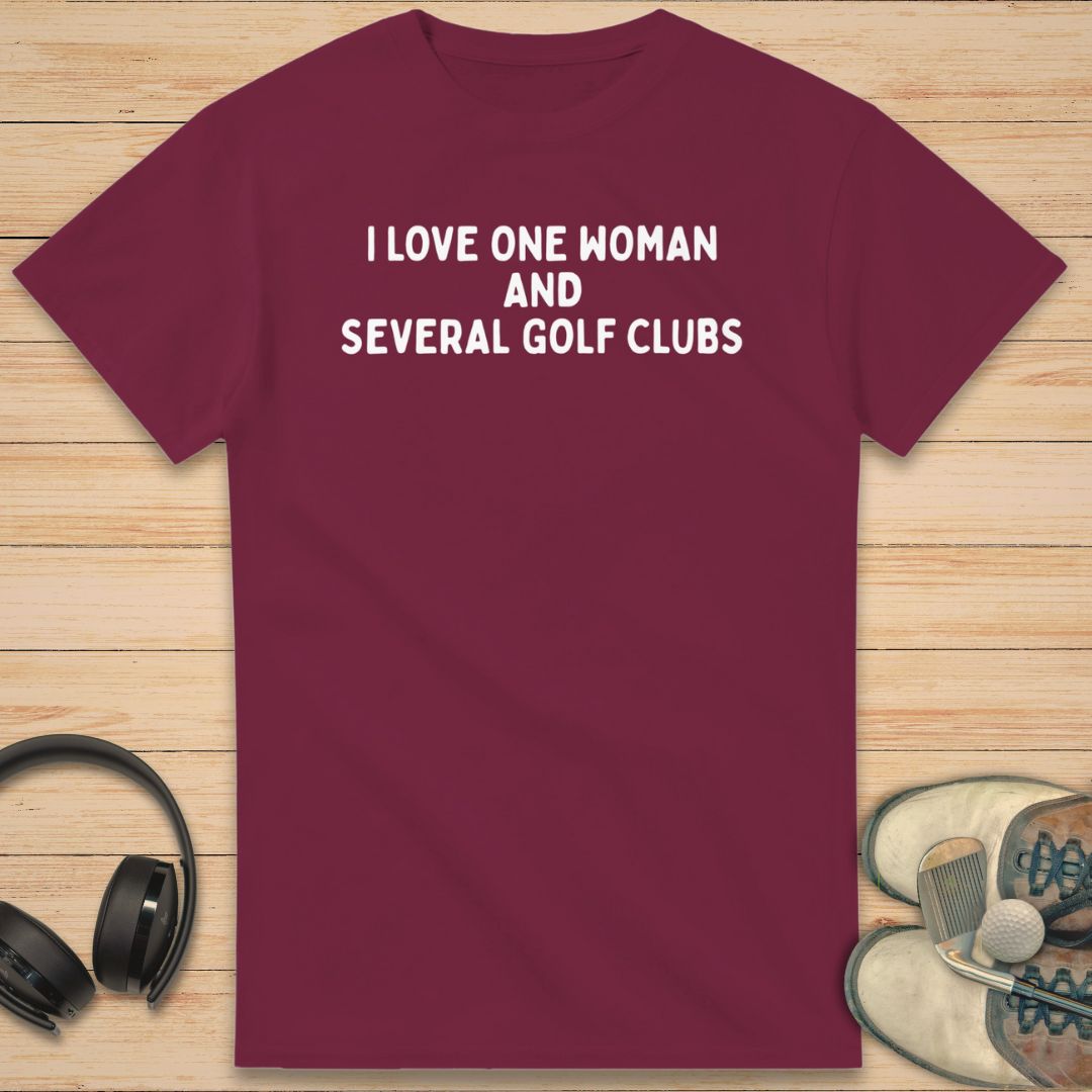 One Woman T-Shirt in Maroon on a light wooden floor lying next to headphones and golf shoes.
