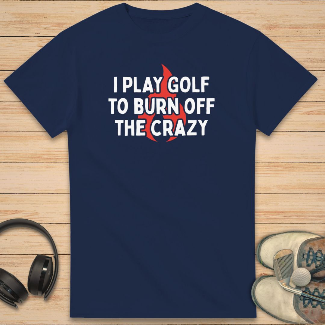 Burn Off T-Shirt in Navy on a light wooden floor lying next to headphones and golf shoes.