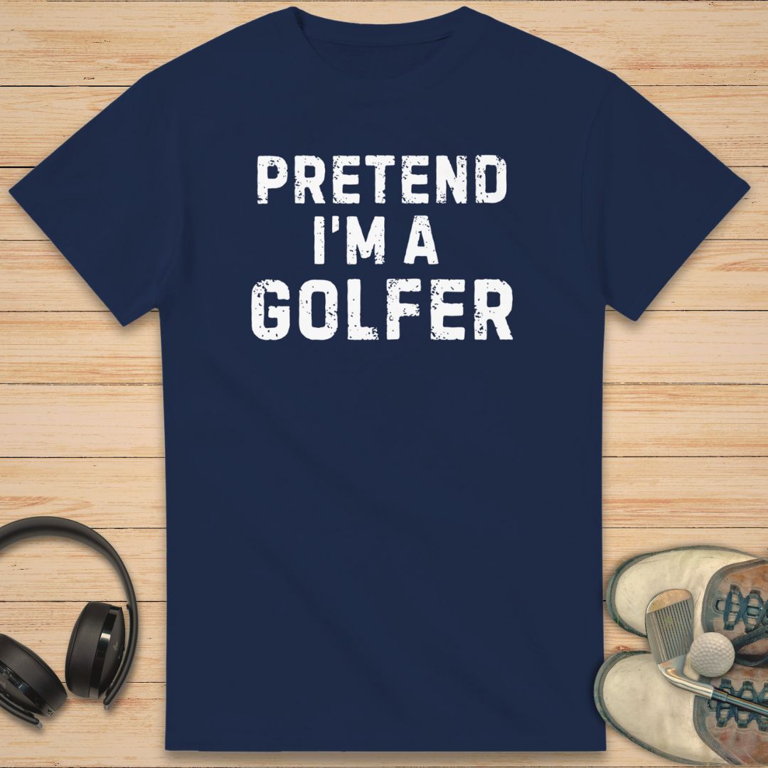 Navy blue t-shirt with 'Pretend I'm a Golfer' text on a wooden surface with headphones and shoes.