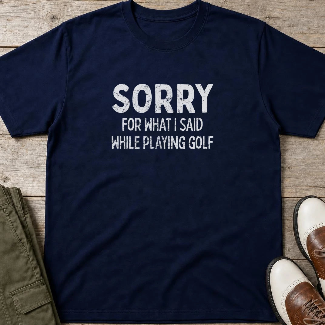 Sorry T-Shirt in Navy lying on a plain floor. T-shirt is a unisex cut and 100 per cent cotton.