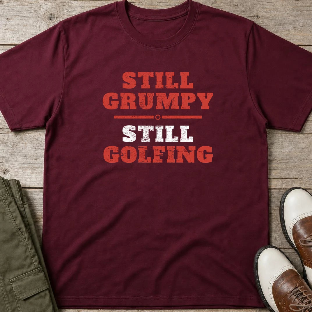 Still Grumpy Red T-Shirt in Maroon lying on a plain floor. T-shirt is a unisex cut and 100 per cent cotton.