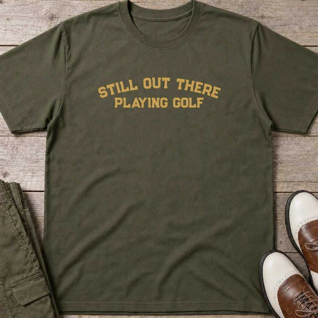 Still Out There T-Shirt in Military Green lying on a plain floor. T-shirt is a unisex cut and 100 per cent cotton.
