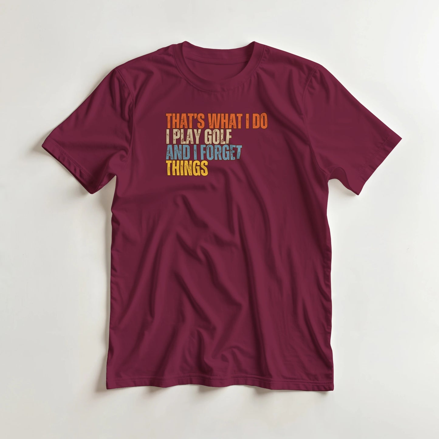 What I Do T-Shirt in Maroon lying on a plain floor. T-shirt is a unisex cut and 100 per cent cotton.