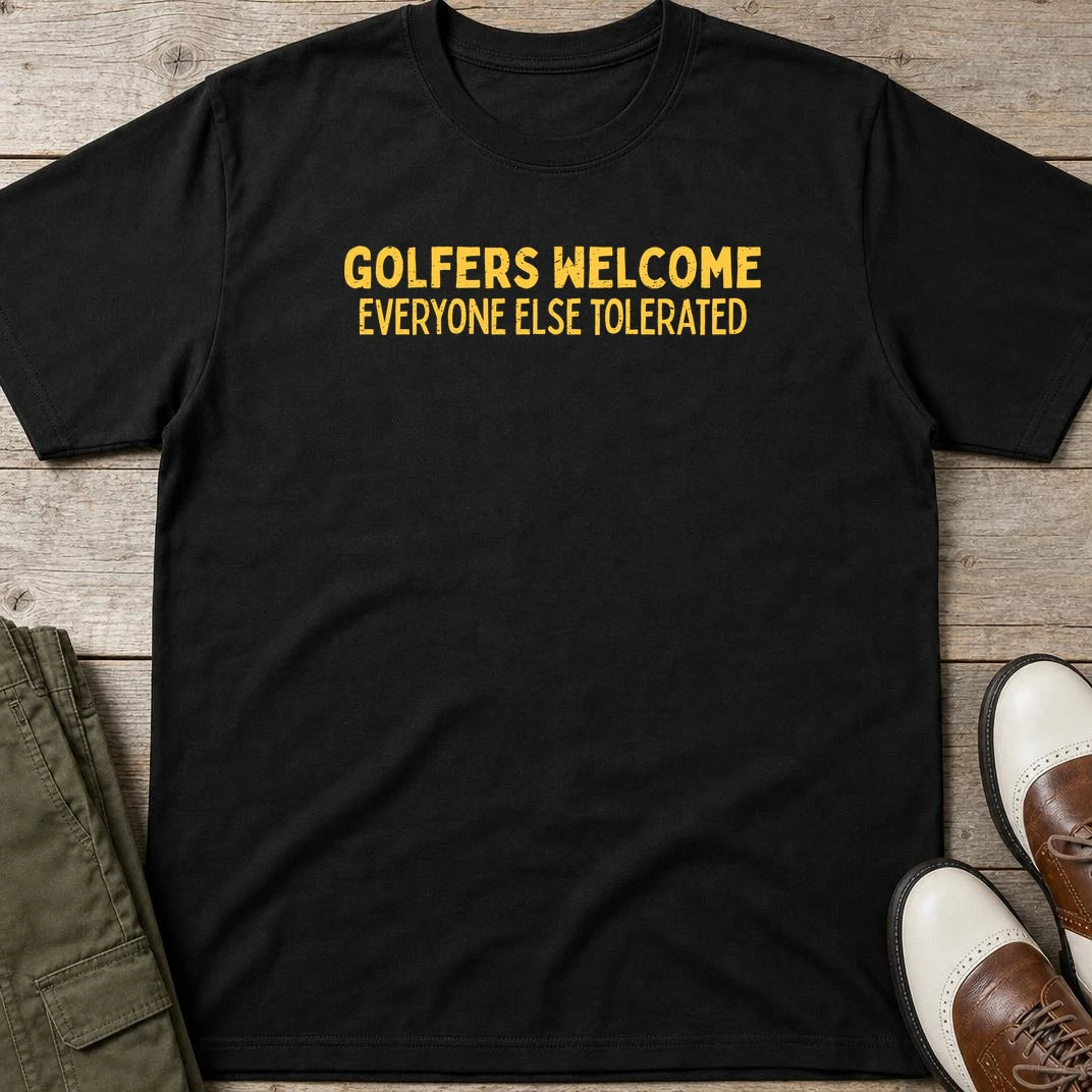Golfers Welcome T-Shirt in Black lying on a plain floor. T-shirt is a unisex cut and 100 per cent cotton.