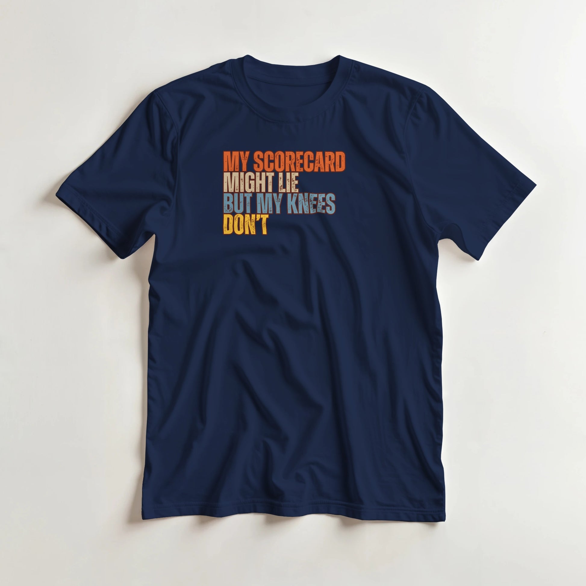Scorecard Might Lie T-Shirt in Navy lying on a plain floor. T-shirt is a unisex cut and 100 per cent cotton.